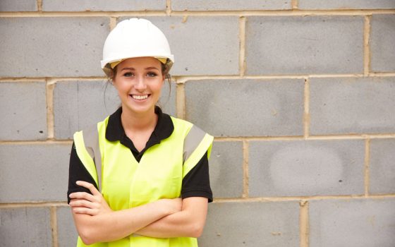 Worker in high vis in front of wall