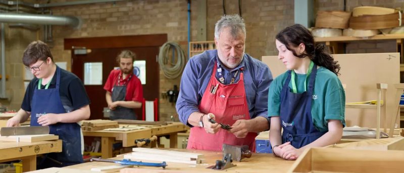 Student and lecturer looking at furniture making tools