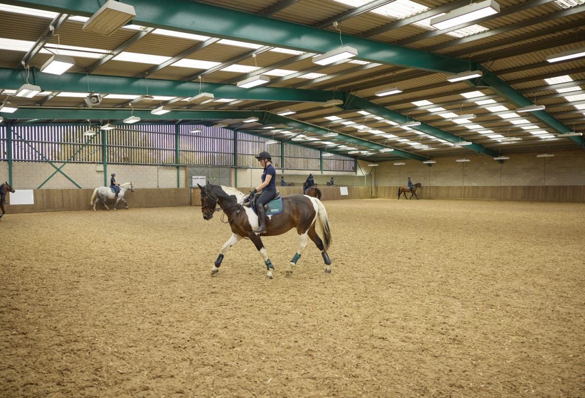 Student riding in large indoor area with more students in background