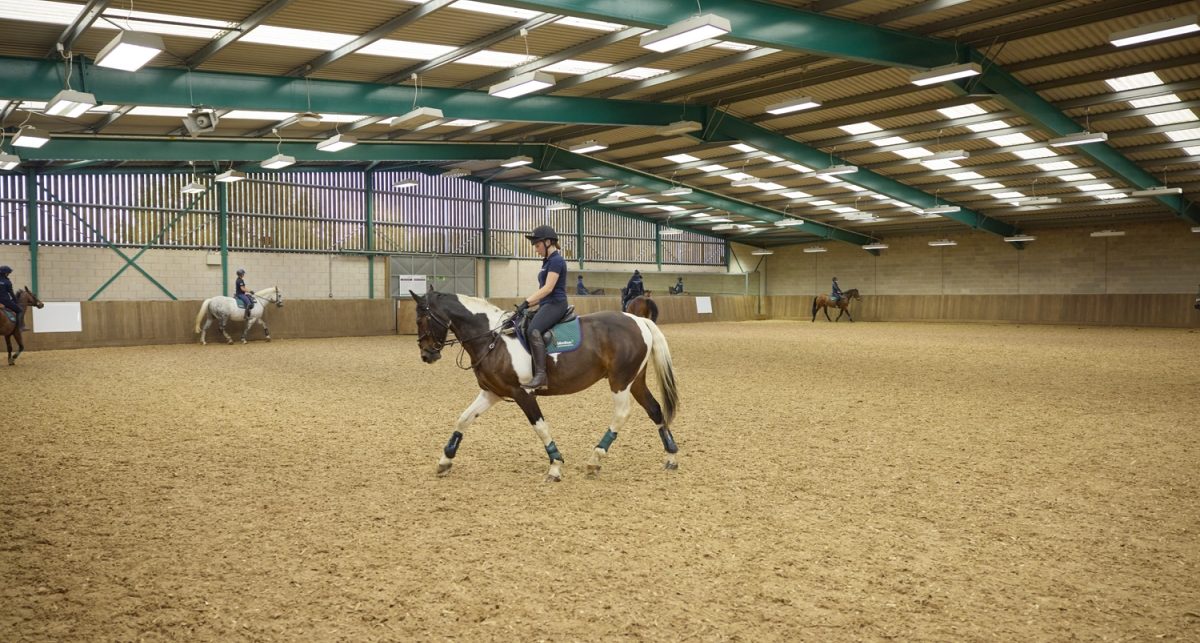 Student riding in large indoor area with more students in background