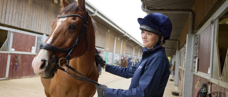 Equestrian Student with horse in stables