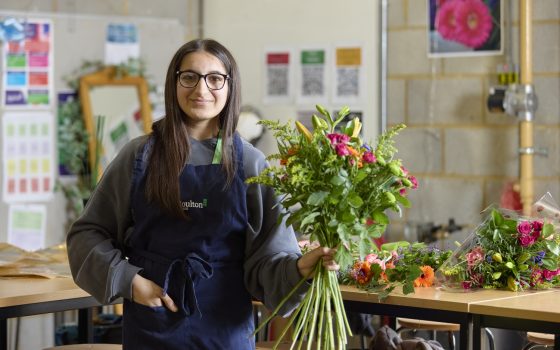 Student holding bouquet of flowers in workshop