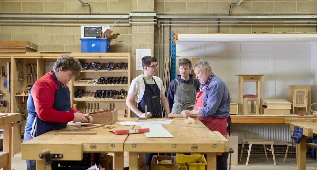 Furniture students and member of staff working together within furniture workshop