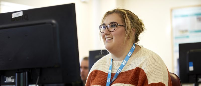 Smiling student in front of PC