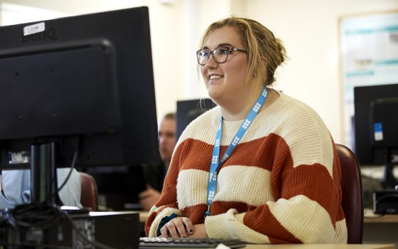 Smiling student in front of PC