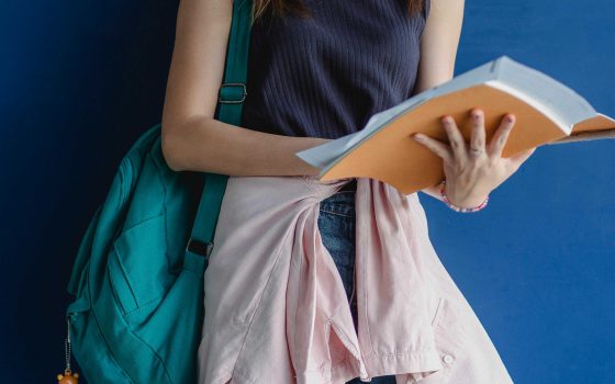 Woman standing holding study book taken by Zen Chung