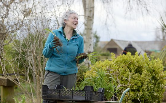 Lady holding plants looking away