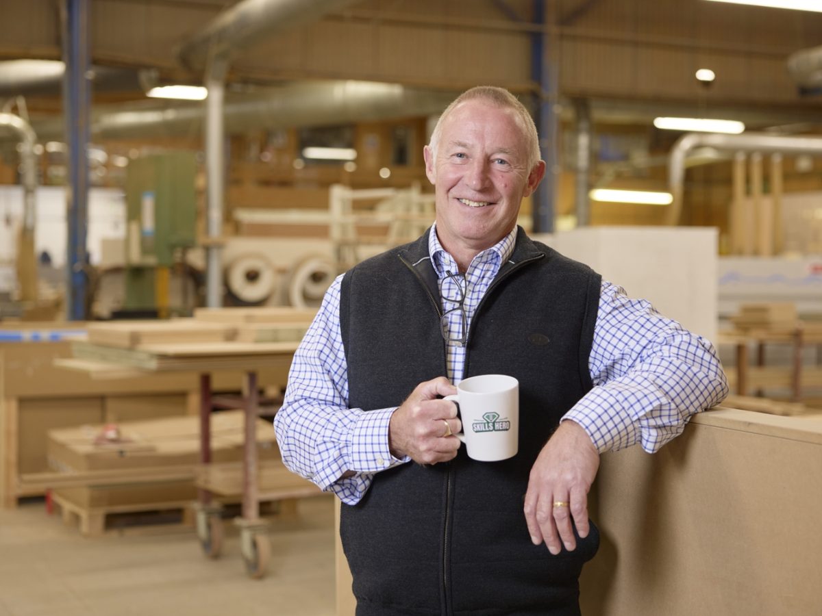 Neil Burke of NBJ with his Skills Heroes mug in the joinery workshop.