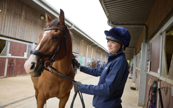 Equestrian Student with horse in stables